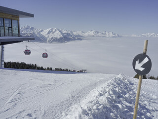 Leere Skipiste mit Gondel und Bergstation in Tirol