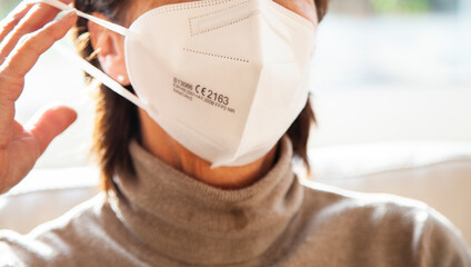Corona Schutzmaske / FFP2 Atemschutzmaske / Frau / Maske aufsetzen / Freizeit / Maskenpflicht /...
