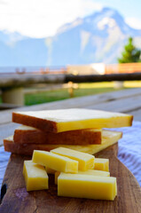 Cheese collection, French comte, beaufort or abondance cow milk cheese served outdoor with Alps mountains peaks on background