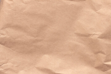 Fototapeta na wymiar Texture of crumpled light brown craft paper.