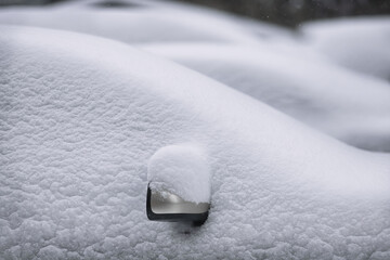 Snowy winter, cars covered with a large layer of snow