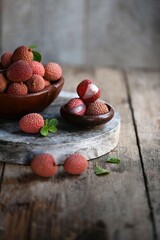 Fresh red lychee fruits.  Fresh organic lychee fruit on a rustic wooden background.