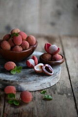 Fresh red lychee fruits.  Fresh organic lychee fruit on a rustic wooden background.