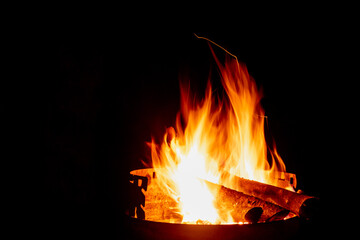 Woods on fire in a barbecue at night.