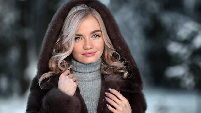 Portrait of lady smiling posing in hood fur coat outdoor. Medium close up shot on 4k RED camera