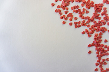 Small red heart sprinkles on white background