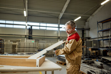 Mid adult craftsman working at carpentry workshop.