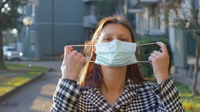 beautiful woman takes off medical mask and smiling for the freedom