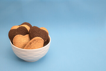 White plate with multi-colored heart-shaped cookies on a blue background