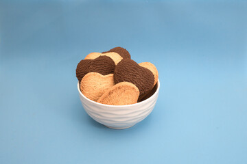 White plate with multi-colored heart-shaped cookies on a blue background