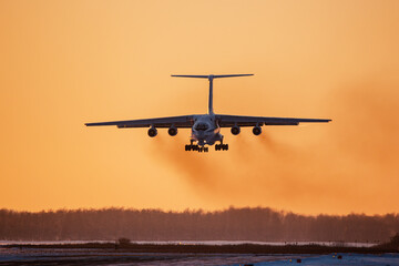 Military transport plane comes in to land on the runway of the airfield