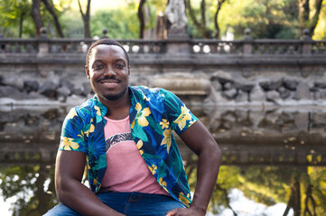 A young black man in park. Outdoor portrait of traveler. Portrait of a young african man in park. Outdoors portrait.