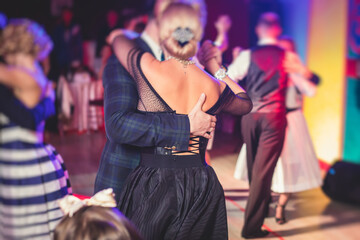Couples dancing traditional latin argentinian dance milonga in the ballroom, tango salsa bachata kizomba lesson in the red lights, dance festival - obrazy, fototapety, plakaty