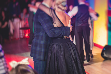Couples dancing traditional latin argentinian dance milonga in the ballroom, tango salsa bachata kizomba lesson in the red lights, dance festival