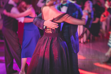 Couples dancing traditional latin argentinian dance milonga in the ballroom, tango salsa bachata kizomba lesson in the red lights, dance festival - obrazy, fototapety, plakaty