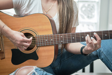 Fototapeta premium girl's hands playing an acoustic guitar