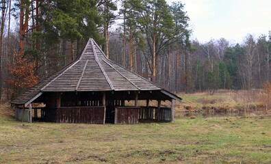 old wooden gazebo in the woods by the pond