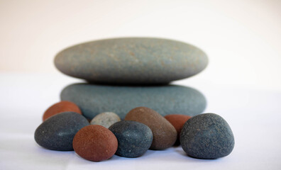 Fototapeta na wymiar Stack of zen pebble stones on white background, relax still life, calm scene.