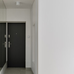 Narrow white corridor with mirror