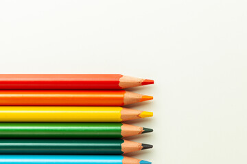 Set of colorful pencils on the warm white background.