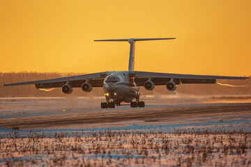 Military transport plane comes in to land on the runway of the airfield