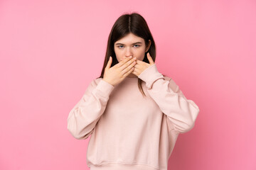 Young Ukrainian teenager girl over isolated pink background covering mouth with hands