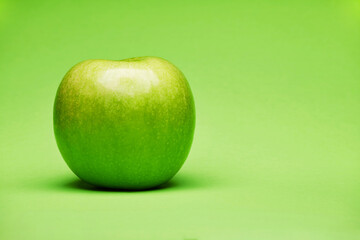 Single raw fresh clean one alone green apple isolated on the bright solid fond plain green background