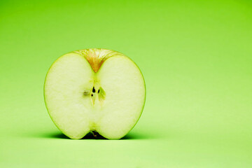 Single raw fresh clean one alone green apple half part stand on the bright solid fond plain green background