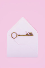 Vintage Love key in an envelope on a pink background, top view