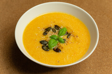 pumpkin puree soup with pumpkin seeds served in a bowl