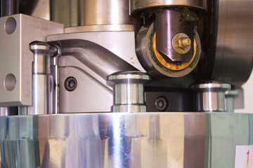 Movement of the punch along the guide chute of the rotary tablet press of the pharmaceutical laboratory for the production and testing of medicines.