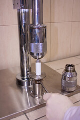 Semi-automatic machine for filling aerosol cans with medicines. Crimping of aluminum caps under compressed air pressure.