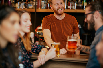 Small group of people leaning on bar counter, chatting and drinking beer.