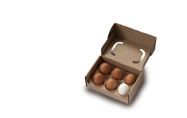 Close-up view of raw chicken eggs in egg box on white wooden background