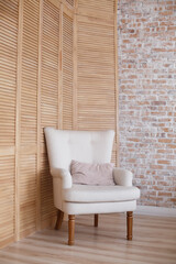 soft armchair near brick and wooden wall. Armchair with fabric upholstery