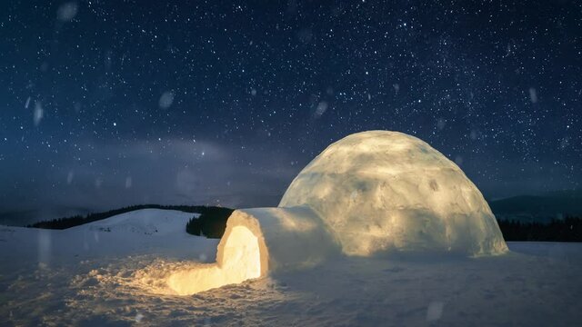 Wintry scene with snowy igloo and milky way in night sky. Fantastic winter landscape glowing by star light. UHD 4k video
