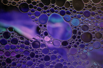 Purple, Blue and Turquoise Oil and Water Abstract Photo. Different sized circles of orange purple...