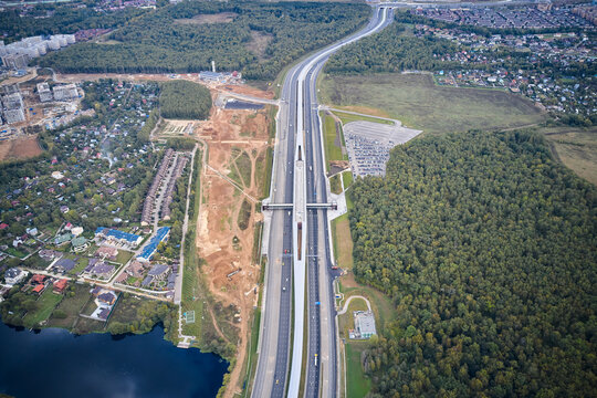 Aerial view of expressway in rural area and subway metro station in the middle
