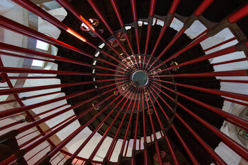 inside spiral steel staircase with red pipes in tower