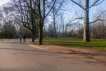 Duas pessoas caminham de mãos dadas em um parque em Amsterdam
