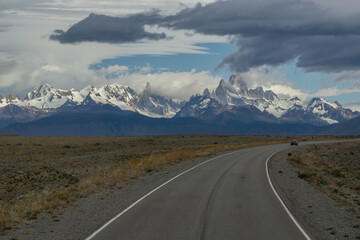 sphalted road with the peaks of a rocky and snowy mountain on the horizon. Fitz Roy mountain in Argentina horizontal Photograph