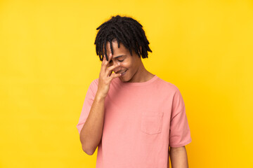 Young african american man isolated on yellow background laughing