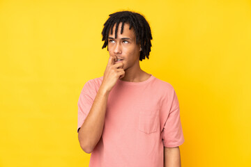 Young african american man isolated on yellow background nervous and scared