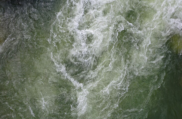 Close up of fast flowing water showing the white foam in the dangerous currents