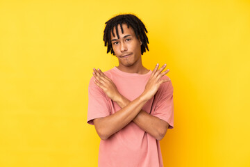 Young african american man isolated on yellow background making NO gesture