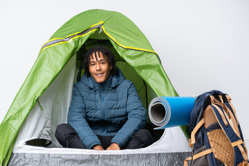Young african american man inside a camping green tent laughing