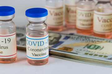 Coronavirus vaccine SARS-CoV-2 bottles and US american dollars banknotes the pandemic on protective surgical mask