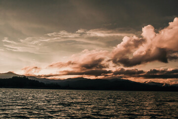 Coastline with cloudy sunset sky, Southern of Thailand sea and mountains on background. Nature in twilight period which including of sunrise over the sea and the nice beach.