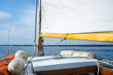 Ein schönes Segelboot bei Sonnenschein auf einem See mit Wind Mast. 
