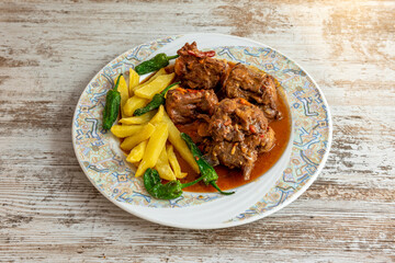 Oxtail garnished with French fries and peppers